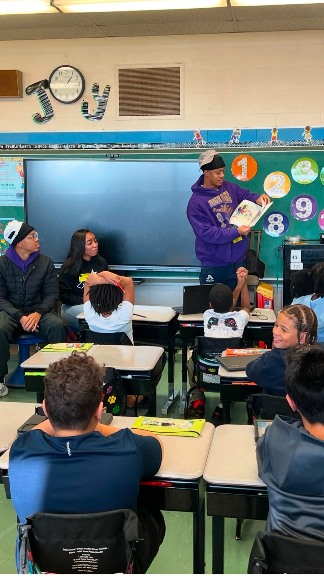 Volunteer reading to students in a classroom.